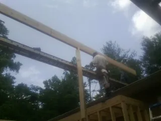 Carpenter setting a ridge beam over a new addition frame — Ice Dam Removal by Roofing Brothers in Garden Valley